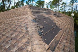 Damaged house roof with missing shingles Hoschton, GA